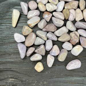 Example of Jade (Purple) tumble stone - pale pink, purple and grey stones with some marbling - on a black background