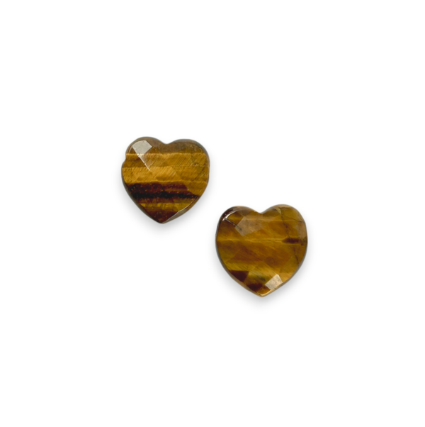 Two Tiger Eye Heart Side-Drilled side by side - faceted hearts containing bands of gold, brown, black - on a white background