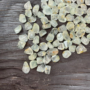 Example of Topaz (Milky Blue with Haematoid) - translucent pale blue tumble stone - on a dark wooden board