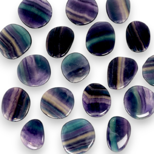 Group of Fluorite Pocket Stones - flat banded purple, blue, green and clear stones - on a white background